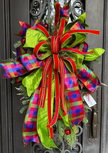 Multicolored Christmas Wreath product image feature a door wreath.  Artificial pine base. Oversized bow. Colors are red, blue and lime green. Measures 24"W X 33"L.