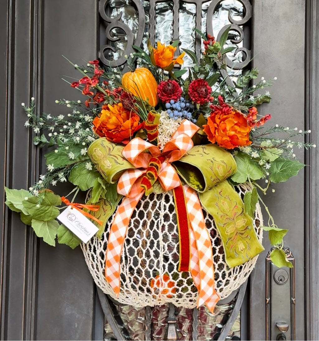 White Pumpkin Wreath product image features a Fall door wreath.   Pumpkin shaped.  Color: white, shades of orange, blue , green.  Materials: grapevine  base, faux silk, foam, velvet, wire.  Dimensions: 30'H x 25"W.    
Indoor/outdoor use under overhang.