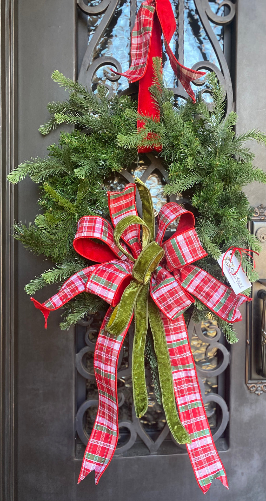 Plaid Christmas Wreath product image features a  round holiday wreath.  Artificial.  Pine .   Handcrafted in Memphis.  Colors are bright red, white and green.   Large bow.  Ribbon hanger.  Measures 24'W X 46" H.   Great for indoors or under over hang outdoors.
