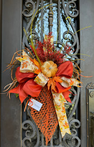 Fall Leaf Door Decor product image features a fall pumpkin wreath.  Color:Burnt orange and gold.  Materials: Metal, velvet, faux silks.  Measures: 35” H X 20”W.  Indoor/outdoor.  Two available for double doors.  Comes ready to hang.