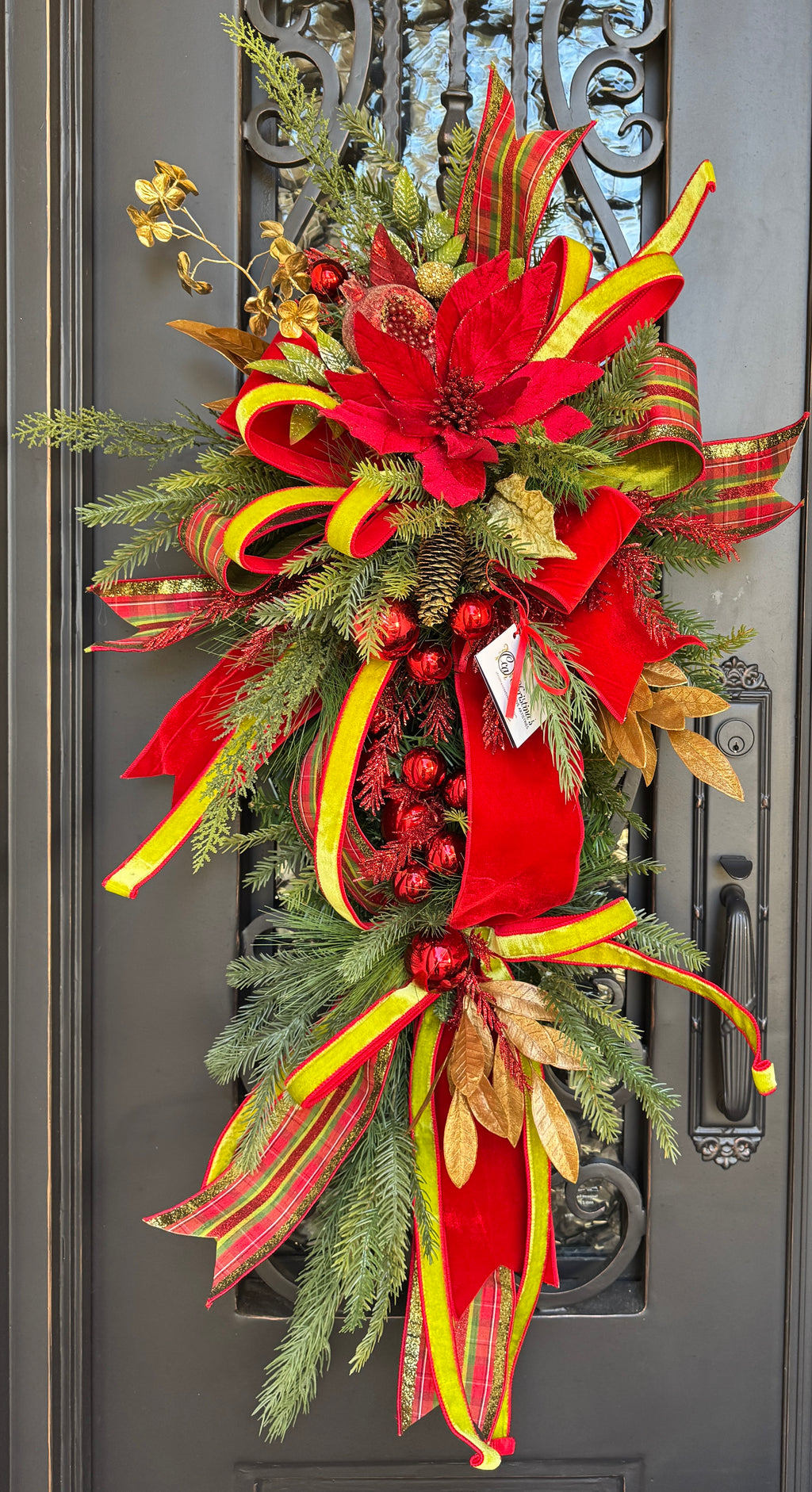 A Whimsical Door Swag with red and green ribbons.