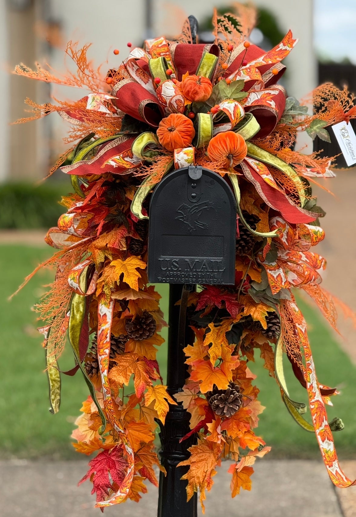 Decorative autumn wreath with ribbons and leaves on a mailbox