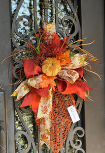 Fall Leaf Door Decor product image features a fall pumpkin wreath.  Color:Burnt orange and gold.  Materials: Metal, velvet, faux silks.  Measures: 35”H X 20”W.  Indoor/outdoor.  Two available for double doors.  Comes ready to hang.