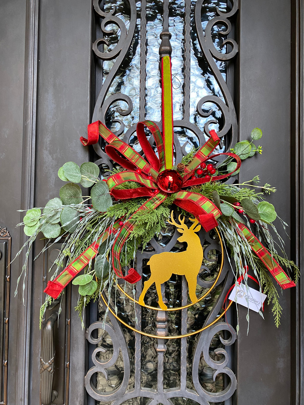 Golden Deer Wreath product image features  a double frame wreath.   Double gold metal rings.  Gold Deer.  Color are red, gold and green.  Measures 29"H X 26" W.    Indoor  or outdoors under overhang.