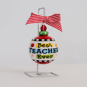 Best Teacher Ever Christmas Ornament product image features, a hand painted ceramic ornament hanging on a metal stand.  Round with red and white striped bow attached.  Slightly raised lettering in black.  Colors are red, green, yellow and light blue.  Comes with silver metal stand.  Hang on tree or on metalstand.