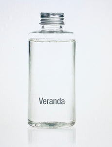 Veranda French Gardenia Porcelain Diffuser Refill product image features a 100ml clear glass bottle filled with french gardenia oil fragrance.  Veranda line of home fragrances in Zodax brand.  The fragrance top notes are fresh bergamot and watery bamboo.  The middle notes are french gardenia, white tuberous and star jasmine.  The base notes are creamy sandalwood, white amber and exotic musk.  Aroma is clean, soft and floral.