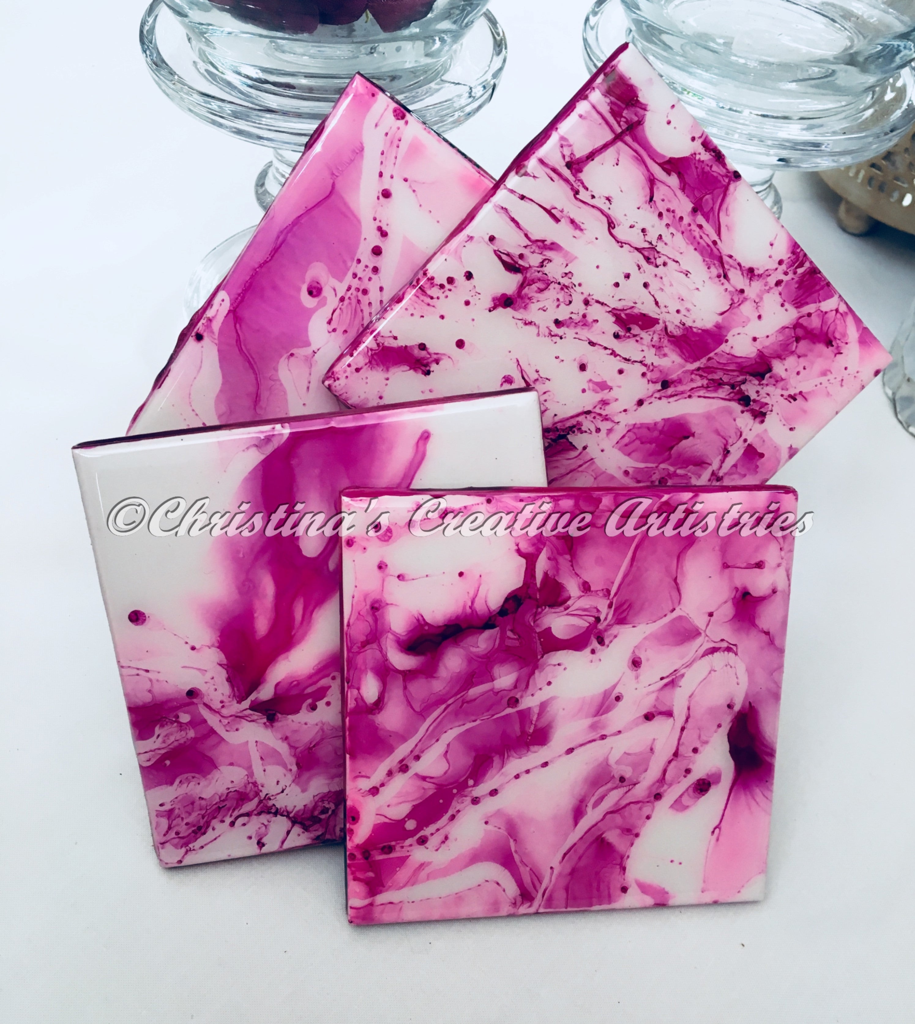 Copy Of Raspberry Squirt product image.  Features 4 inch by 4 inch ceramic coasters.  Set of 4.  Color is fuchsia on white background.  Cork backed. Durable coating.  1 acrylic coaster stand included.  