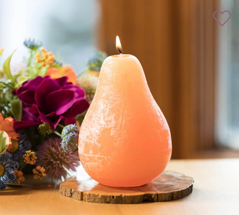 Timber Pear Candle Tangerine product image features one pear shaped candle on a round wood tray.  Candle is lit. Vance Kitira Collection.  Unscented. Color: tangerine.  Burns clean , smokeless , environmentally-friendly. 40 hour long burn time. Measures 3" X 4.5".   Round wood tray not included.