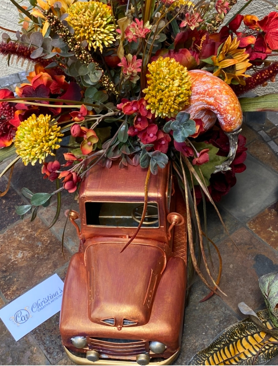 Up close image of Orange Truck Fall Floral  arrangement.