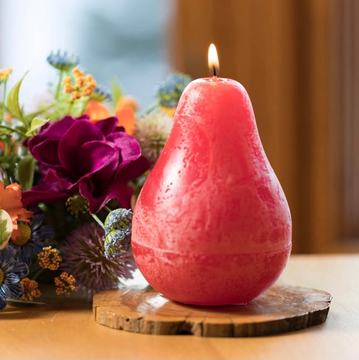 Timber Pear Candle Cranberry product image features one pear shaped candle. Vance Kitira Collection.   Cranberry color. This candle burns clean , smokeless , environmentally-friendly and boast long burn time.  Measures 3"L X 4.5"H. Wood tray not included.  Hammered metal tray candleholders and gold rimmed rectangular trays available for purchase in store.