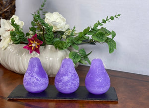 Timber Pear Candle Wisteria product image features a set of three pear shaped candles on a slate tray.  Vance Kitira Collection. Color is wisteria. This candle burns clean , smokeless , environmentally-friendly and boast long burn time. Measures 3"L X 4.5"H.   Slate tray not included.