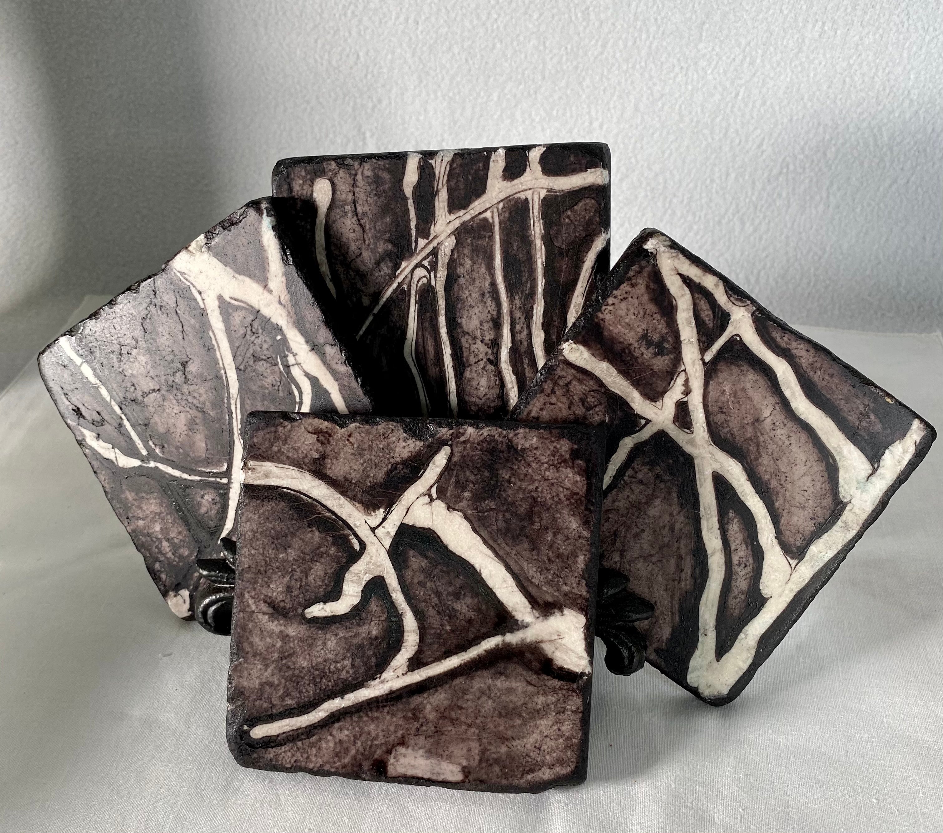 Black And White Drink Coasters product image features a set of four stone coaters.  Hand painted.  Finished to last. Signed.  Cork backed.  Botticino marble tiles. black and white design.  Wipe with damp cloth.  Measures 4" X 4".  Gift wrapped for Father's Day.