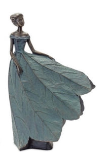 Garden Lady Figurine product image features a lady figurine in a long flowy dress. Hands resting on her dress.  Made of resin. Bronze and patina color.  21.25"H.  Available to ship immediately.