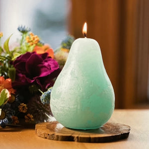 Timber Pear Candle Seafoam product image features one pear shaped candle.  Vance Kitira Collection.  Seafoam color.  This candle  burns clean , smokeless ,  environmentally-friendly and boast long burn time.   Measures 3"L X 4.5"H.  Wood tray not included.  Hammered metal trays and gold rimmed glass trays available for purchase in store.